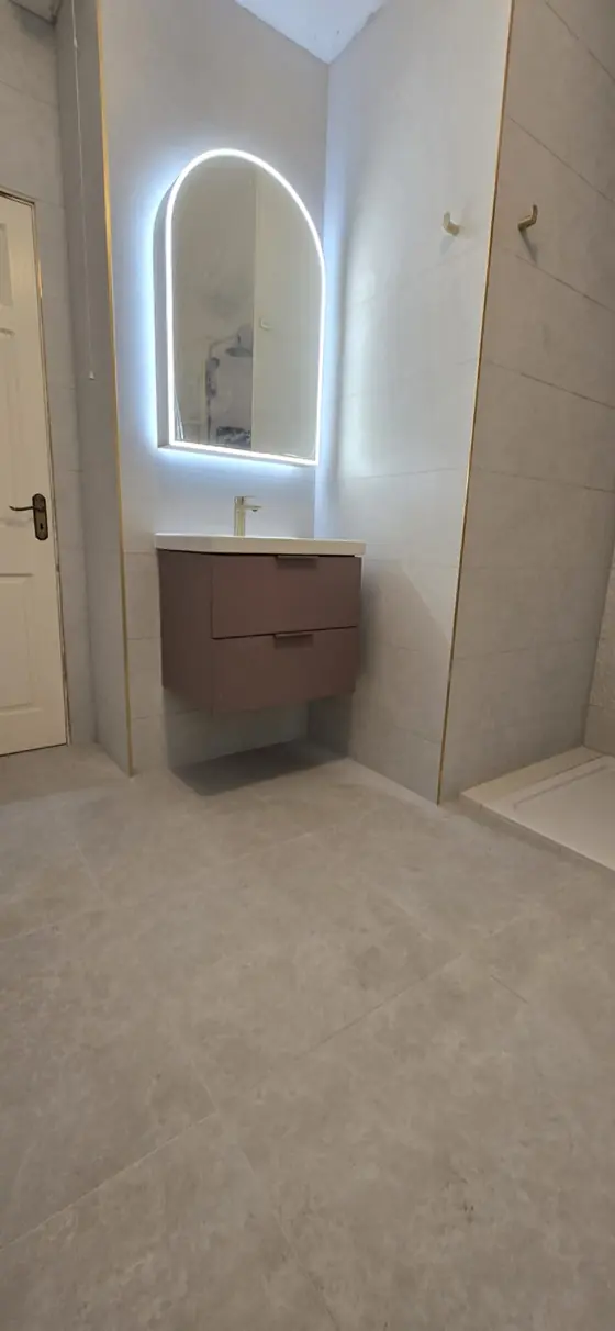 Bathroom renovation with arched LED mirror and wall-hung vanity unit in Cork