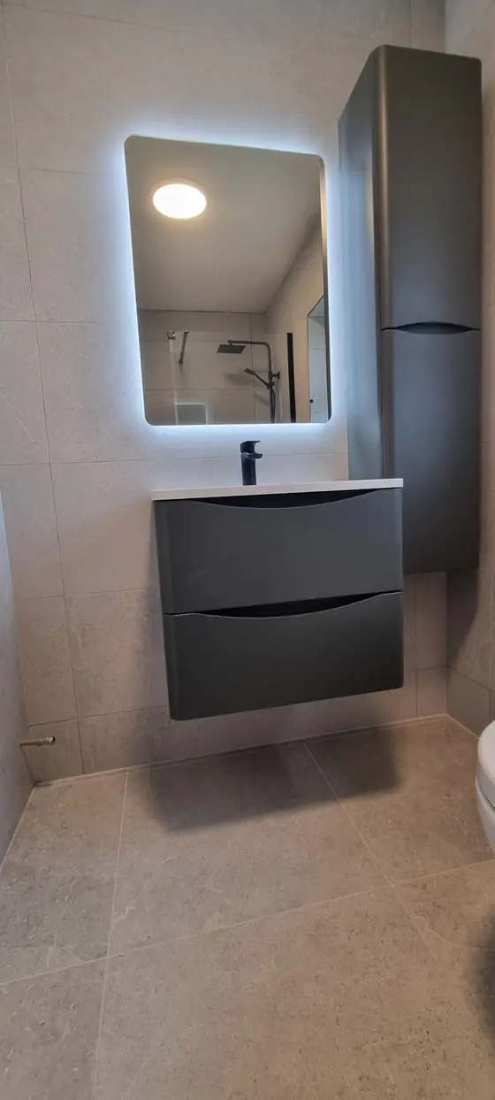 Floating vanity unit with backlit LED mirror in a renovated bathroom, Cork