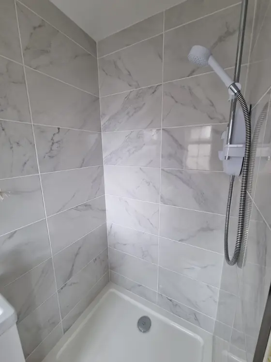 Marble-effect wall tiles around a bath and shower, bathroom tiling in Cork