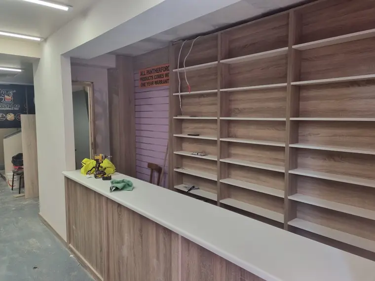 Fitted shelving wall with timber counter, commercial fit-out Cork