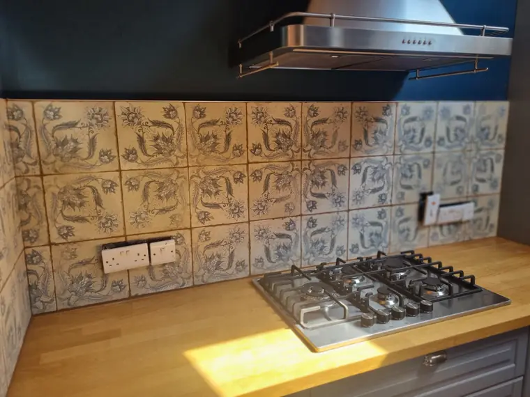 Decorative patterned tile splashback behind a gas hob, kitchen tiling in Cork