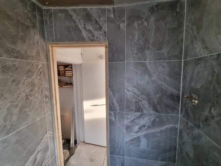 Wet room wall tiling with large-format porcelain tiles, Cork
