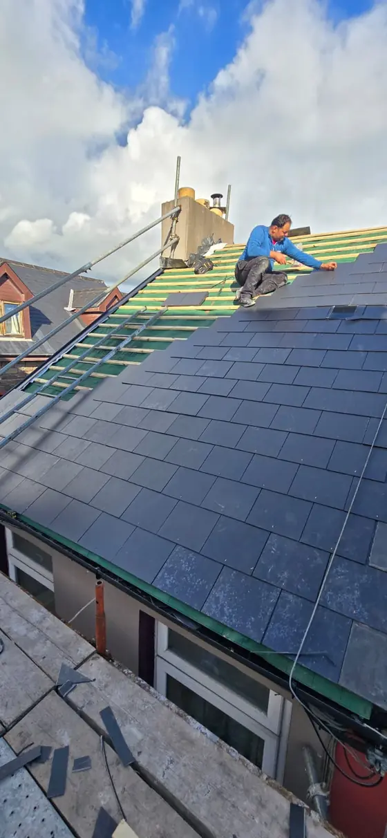 Roofer fitting a new slate roof on a house in Co. Cork